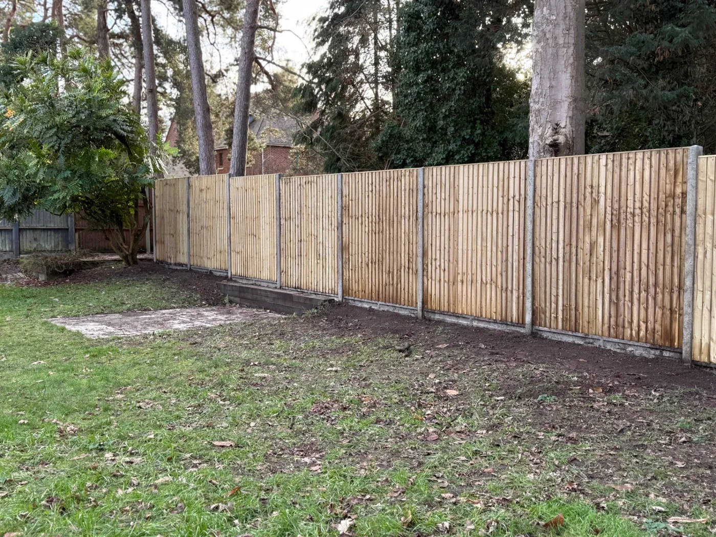 Long run of closeboard fencing installed at the edge of woodland