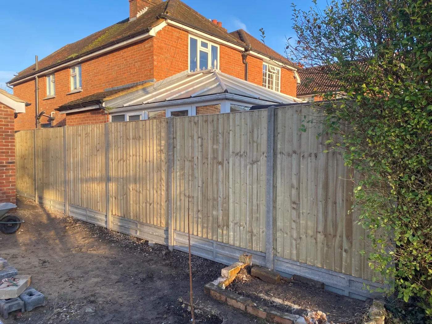 New closeboard garden fence with concrete posts and gravel boards in a garden